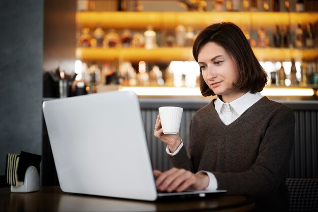 Mittlere Schussfrau, die am Laptop arbeitet