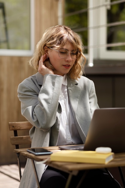 Mittlere Schussfrau, die am Laptop arbeitet