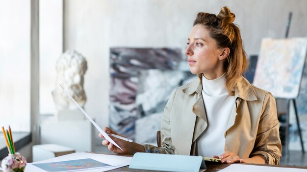 Mittlere Schussfrau, die am Schreibtisch sitzt