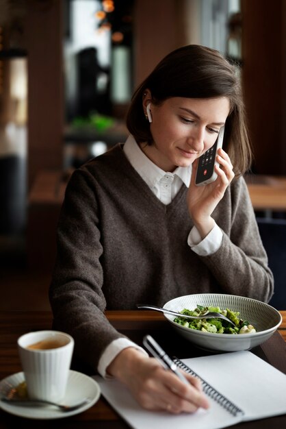 Mittlere Schussfrau, die am Telefon spricht