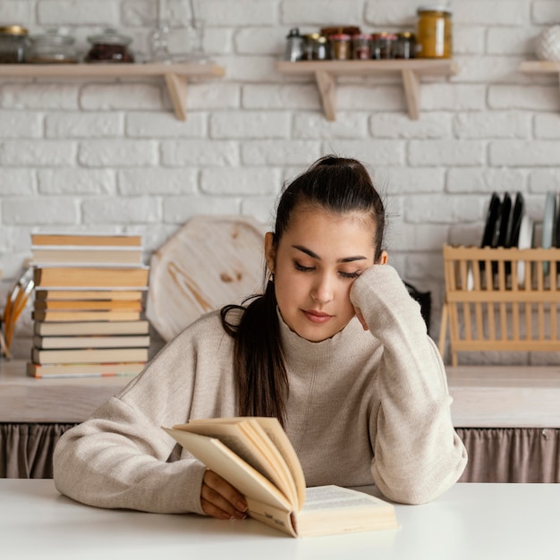 Mittlere Schussfrau, die am Tisch liest