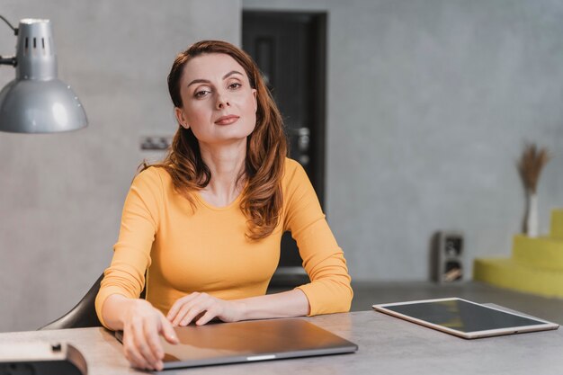 Mittlere Schussfrau, die am Tisch sitzt