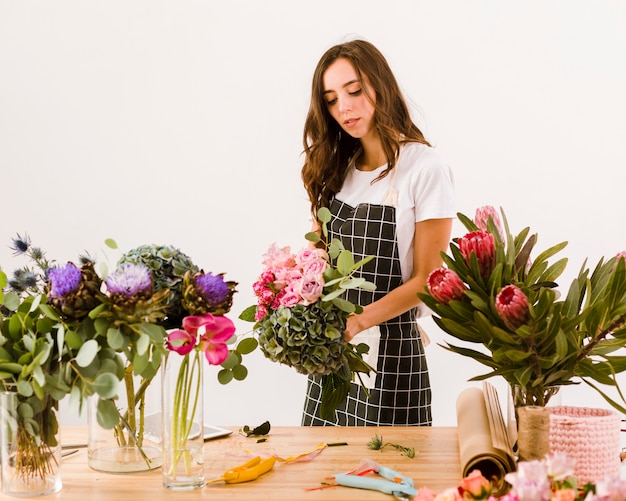 Mittlere Schussfrau, die an einem Blumenladen arbeitet