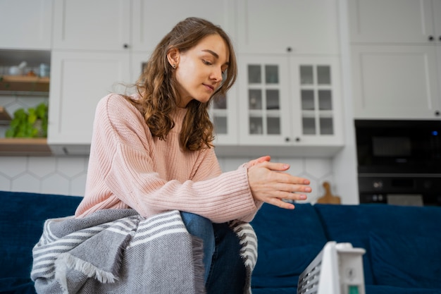 Mittlere Schussfrau, die auf Couch sitzt