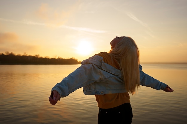 Mittlere Schussfrau, die bei Sonnenuntergang aufwirft