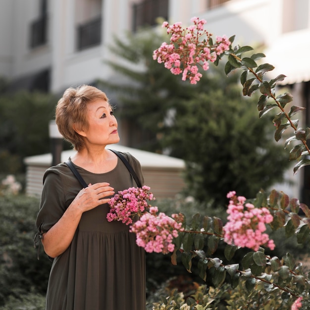 Mittlere Schussfrau, die Blumen betrachtet