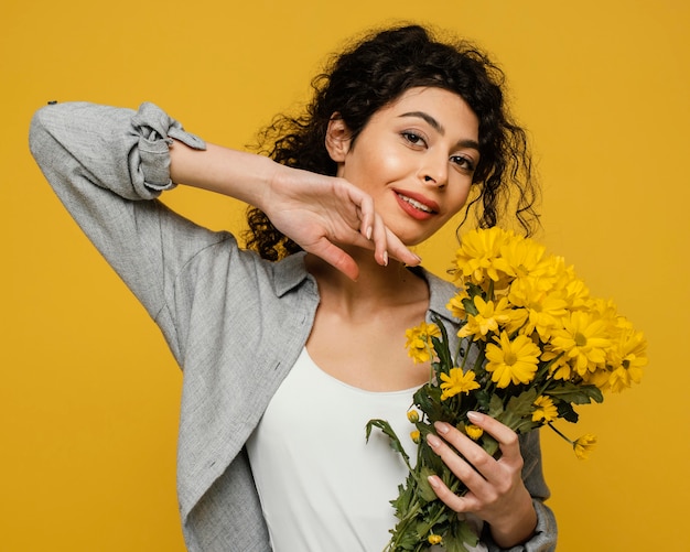 Kostenloses Foto mittlere schussfrau, die blumen hält