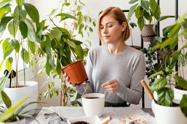 Mittlere Schussfrau, die Blumentopf hält