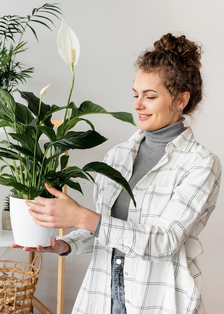 Kostenloses Foto mittlere schussfrau, die blumentopf hält