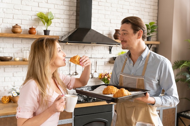 Mittlere Schussfrau, die Croissant isst