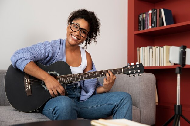 Mittlere Schussfrau, die die Gitarre spielt