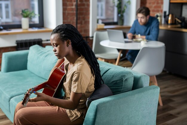 Mittlere Schussfrau, die die Gitarre spielt