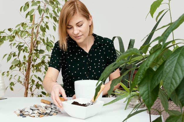 Mittlere Schussfrau, die drinnen im Garten arbeitet