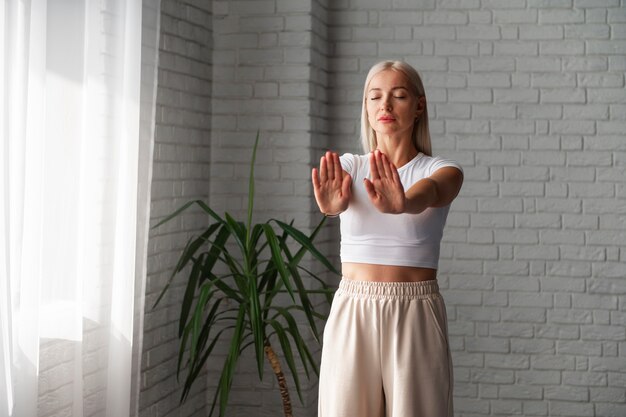 Mittlere Schussfrau, die drinnen Tai Chi praktiziert