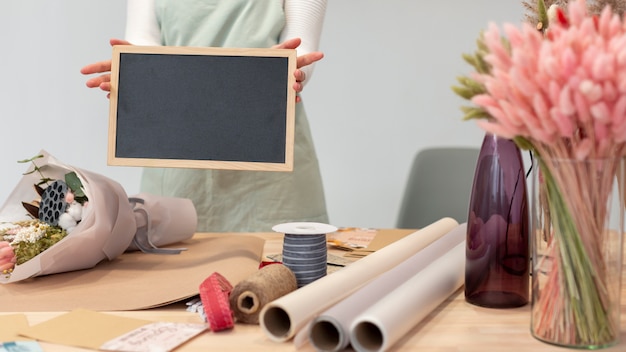 Mittlere Schussfrau, die eine leere Kopierraumtafel hält