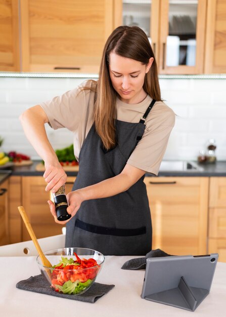 Mittlere Schussfrau, die Essen würzt