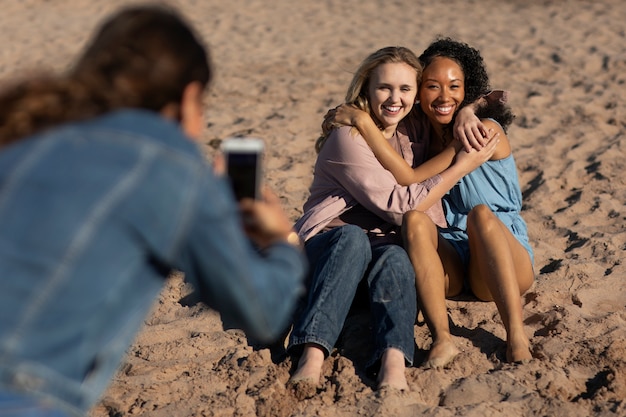 Mittlere Schussfrau, die Fotos mit Telefon macht