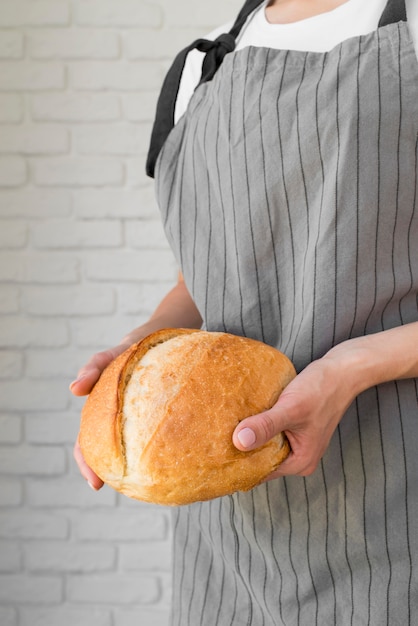 Mittlere Schussfrau, die frisches Brot hält