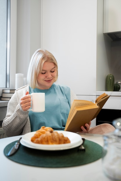 Kostenloses Foto mittlere schussfrau, die frühstückt