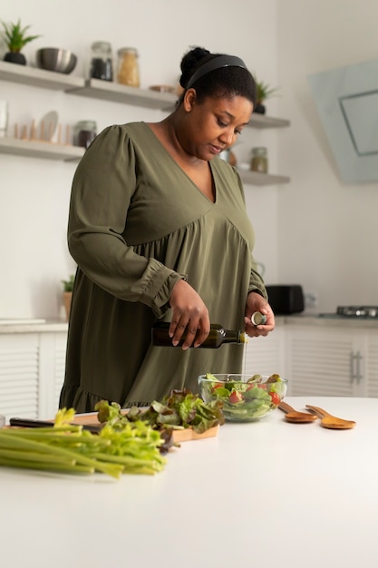 Mittlere Schußfrau, die gesundes Essen kocht