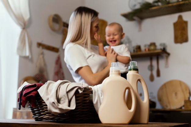 Kostenloses Foto mittlere schussfrau, die glückliches kind hält