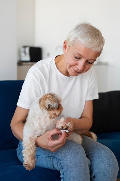 Mittlere Schussfrau, die Hund putzt