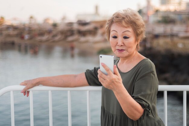 Mittlere Schussfrau, die ihr Telefon überprüft