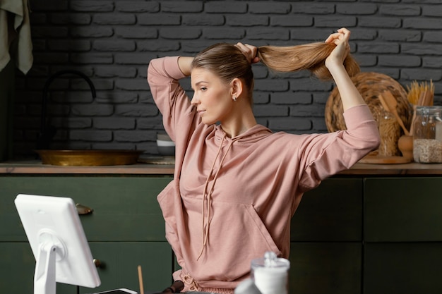 Kostenloses Foto mittlere schussfrau, die ihre haare bindet