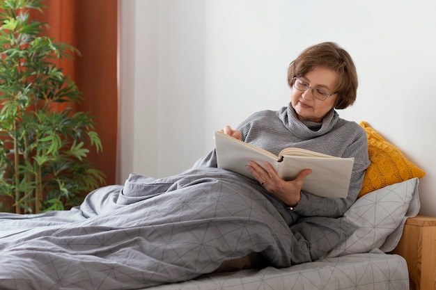 Mittlere Schussfrau, die im Bett liest