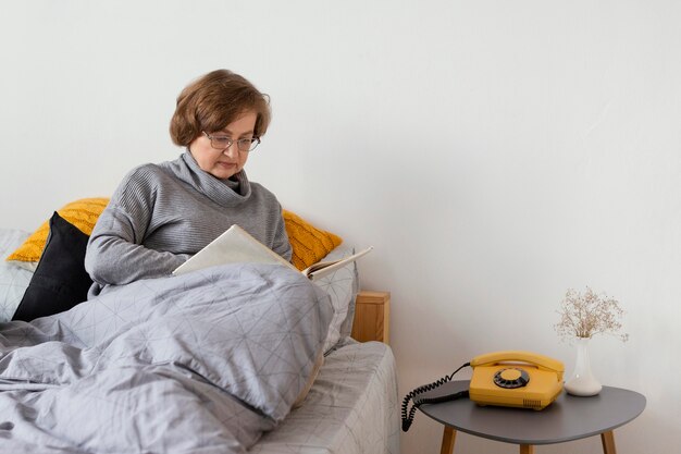 Mittlere Schussfrau, die im Bett sitzt
