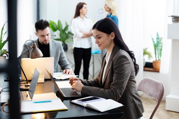 Mittlere Schussfrau, die im Büro arbeitet