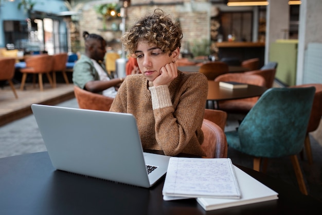 Mittlere Schussfrau, die in der Kaffeestube liest