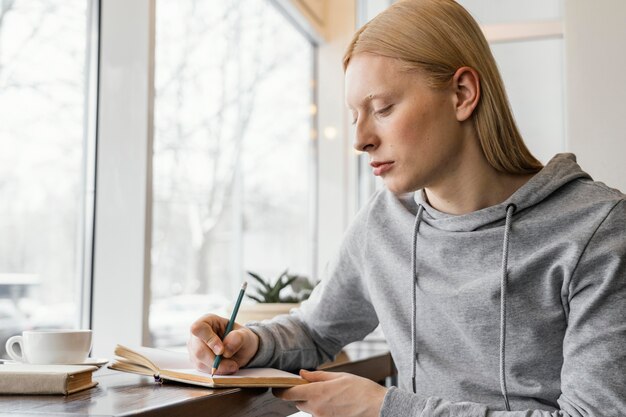 Mittlere Schussfrau, die in Notizbuch schreibt