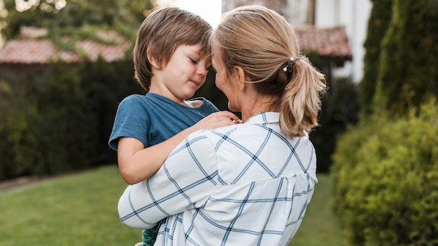 Mittlere Schussfrau, die Jungen umarmt