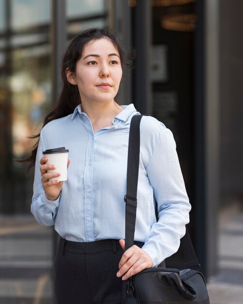 Mittlere Schussfrau, die Kaffee hält