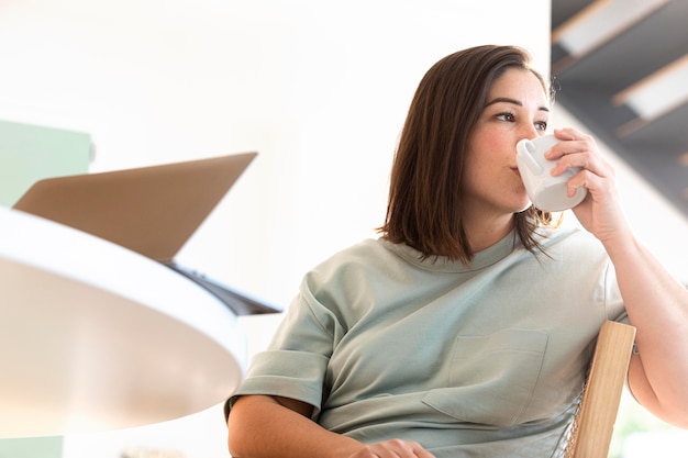 Mittlere Schussfrau, die Kaffee trinkt