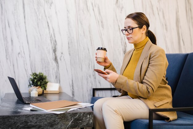 Mittlere Schussfrau, die Kaffeetasse hält