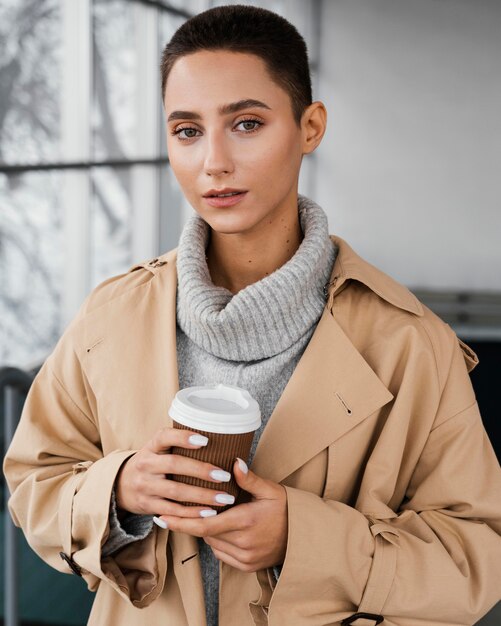 Mittlere Schussfrau, die Kaffeetasse hält