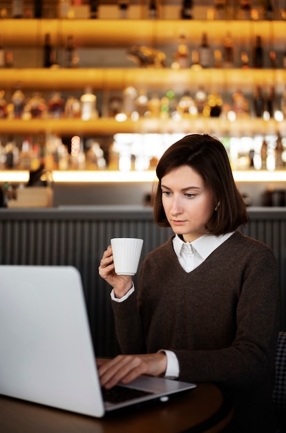 Kostenloses Foto mittlere schussfrau, die kaffeetasse hält