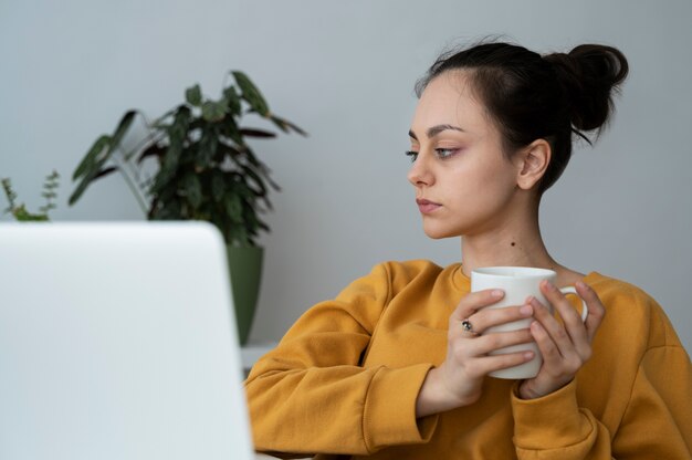 Mittlere Schussfrau, die Kaffeetasse hält