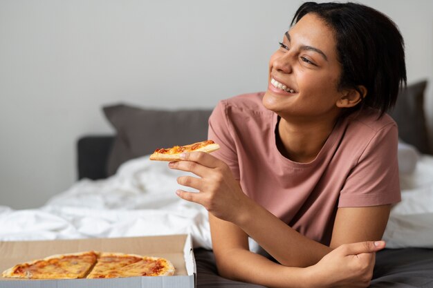 Mittlere Schussfrau, die köstliche Pizza isst