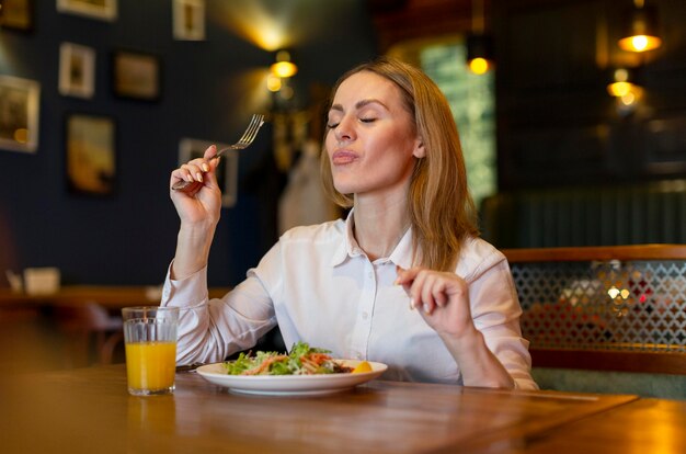 Mittlere Schussfrau, die köstliches Essen isst