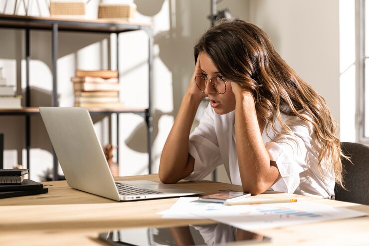 Kostenlose Foto mittlere schussfrau, die laptop betrachtet