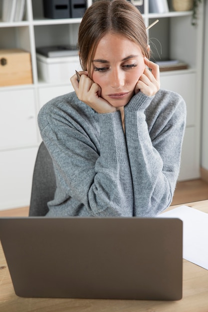 Mittlere Schussfrau, die Laptop betrachtet