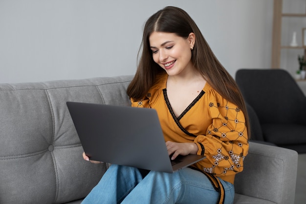 Kostenloses Foto mittlere schussfrau, die laptop hält