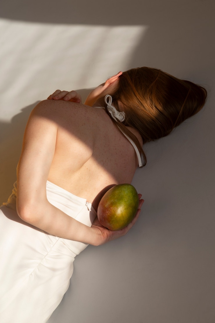 Kostenlose Foto mittlere schussfrau, die mango hält