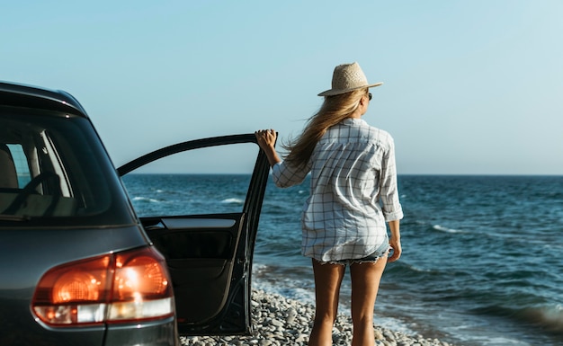 Mittlere Schussfrau, die Meer mit dem Auto betrachtet