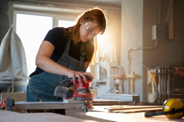 Mittlere Schussfrau, die mit Ausrüstung arbeitet