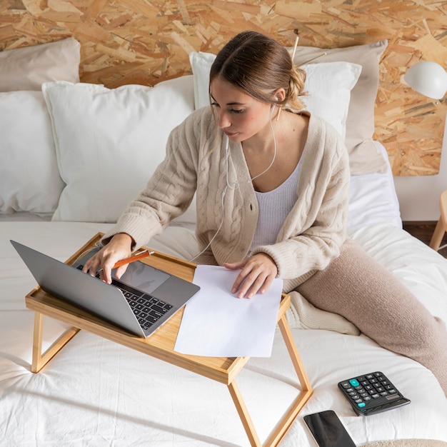 Mittlere Schussfrau, die mit Laptop arbeitet