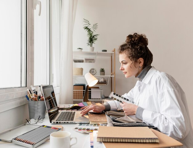 Mittlere Schussfrau, die mit Laptop arbeitet